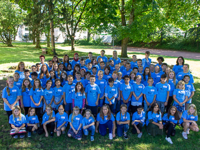 Gruppenfoto Schüler*innen in einem Garten mit blauen T-Shirts