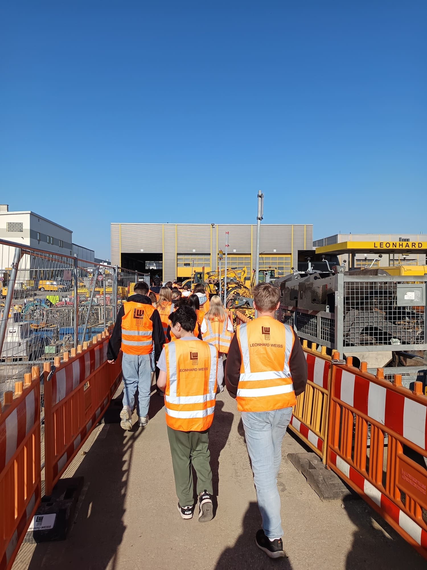 Schulgruppe läuft über das Leonhard-Weiss Gelände durch eine schmale Gasse.