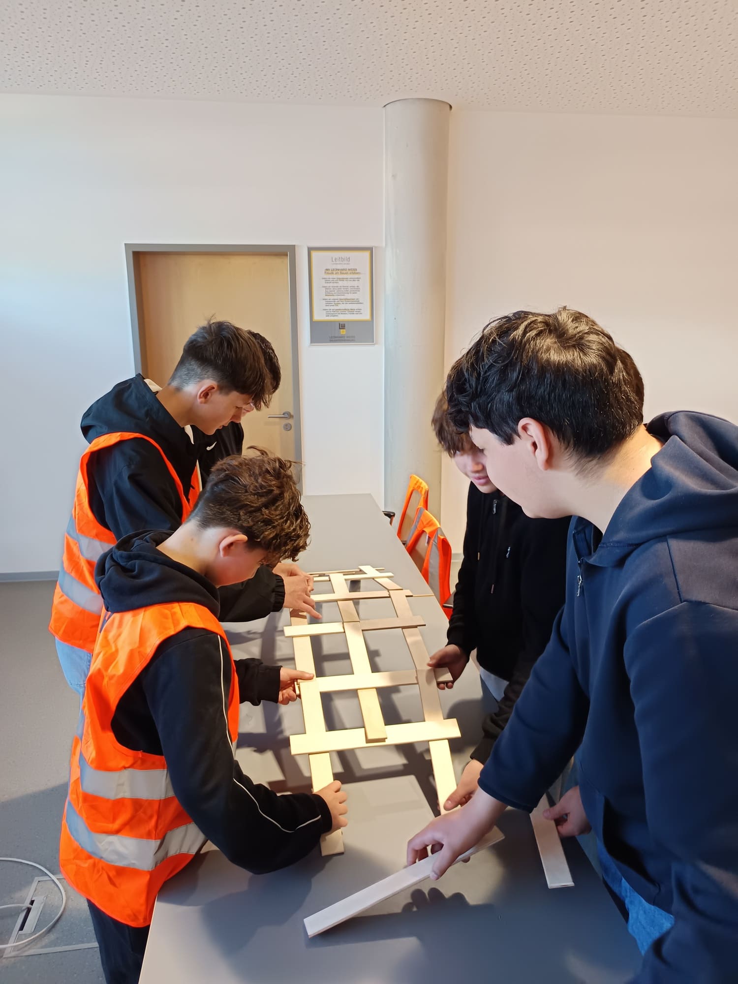 Eine kleine Gruppe an Schülern baut eine Brücke
