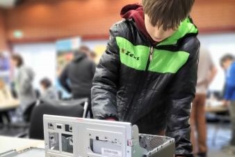 Ein Schüler der an einer Art PC bastelt