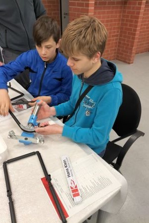 zwei Schüler, die mit einer Biegevorrichtung arbeiten