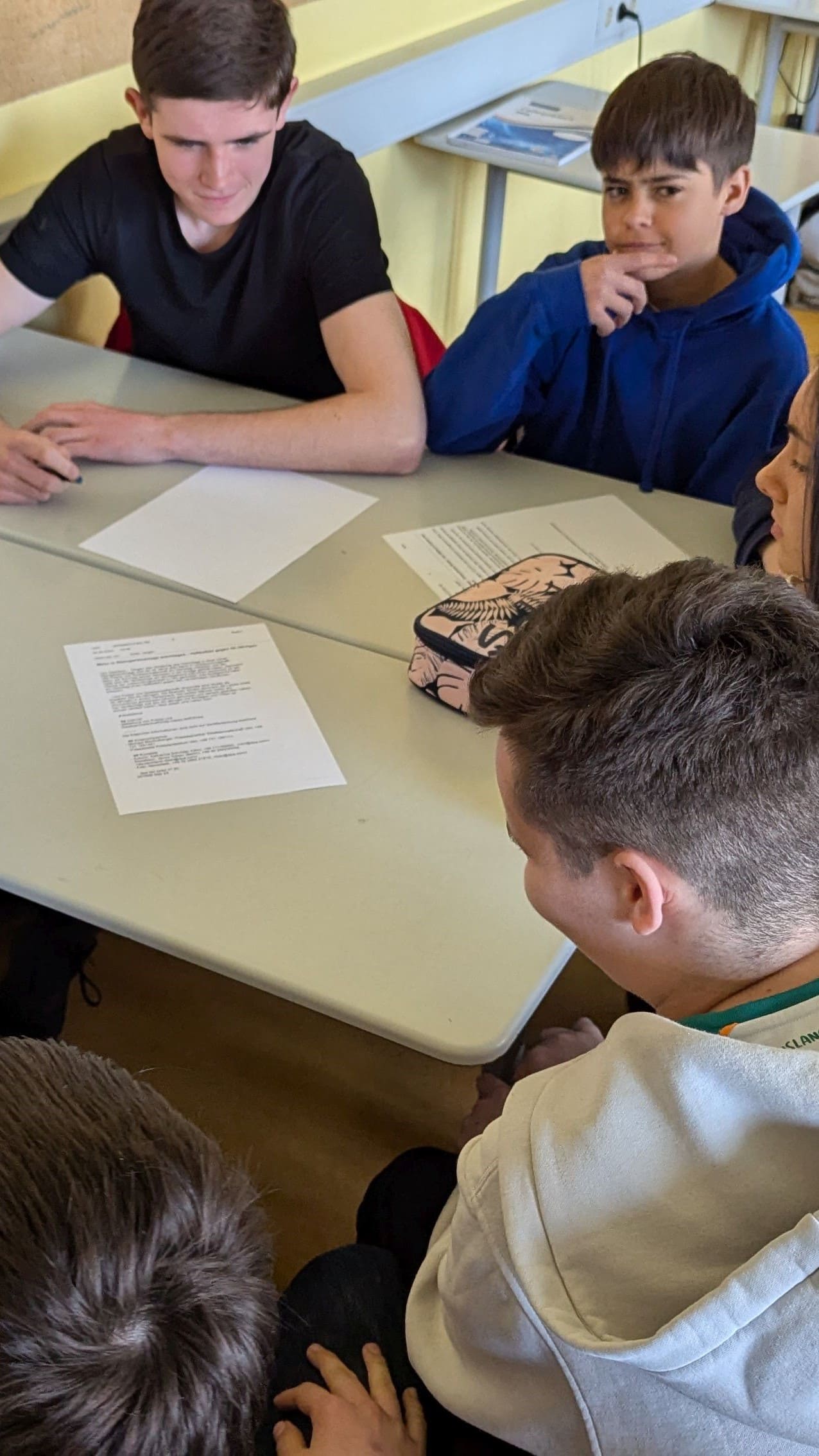 Schüler sitzen und arbeiten gemeinsam am Tisch