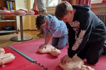 zwei Jungs die einer Reanimation an einer Puppe durchführen