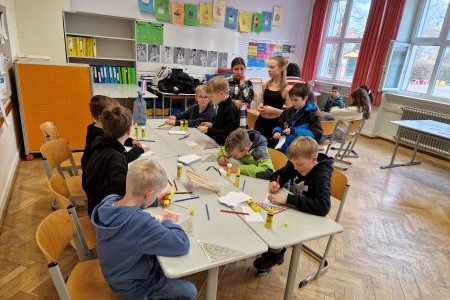 Mehrere Personen, die in einem Klassenzimmer an einem Tisch sitzen