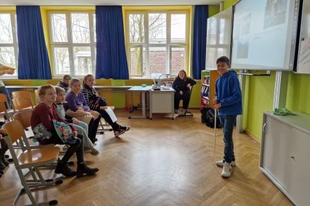 Ein Junge der vor Personen steht und etwas vorträgt