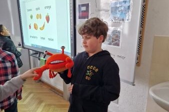 Ein Junge hält ein Krebsstofftier in der hand