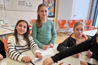 3 Mädchen, die an einem Tisch sitzen