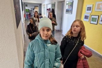 Personen die einen Gang in der Schule entlang laufen