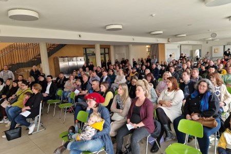 Mehrere Personen versammelt, die auf Stühlen sitzen