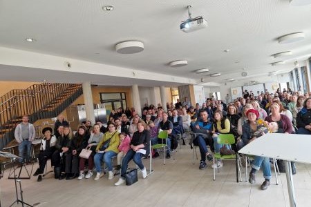 Mehrere Personen versammelt, die auf Stühlen sitzen